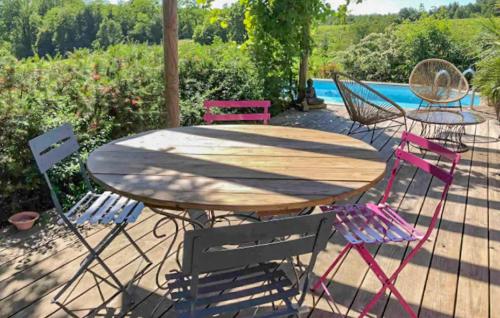 a wooden table with four chairs around it at Stunning Home In Mombrier With Private Swimming Pool, Can Be Inside Or Outside in Mombrier