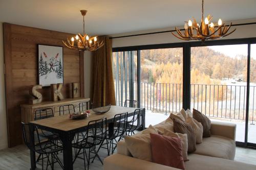 ein Wohnzimmer mit einer Couch und einem Tisch mit Stühlen in der Unterkunft chalet Des Cimes de Risoul in Risoul