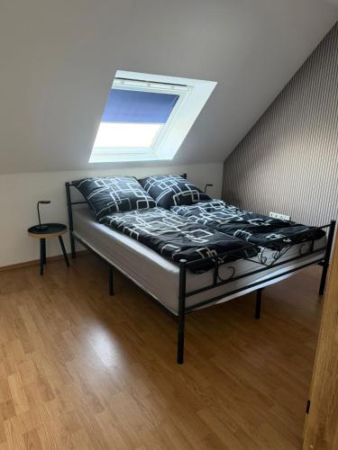 Bett in einem Schlafzimmer mit Dachfenster in der Unterkunft Fewo Hammelblick in Xanten