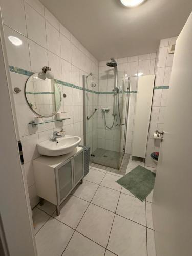 ein Badezimmer mit Dusche, Waschbecken und Spiegel in der Unterkunft Fewo Hammelblick in Xanten