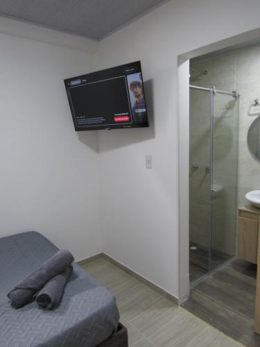 a bedroom with a television hanging on the wall at Lux Al Wafa in Bogotá