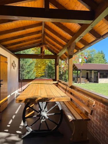 ein hölzerner Picknicktisch in einem Pavillon mit einer Bank in der Unterkunft Vâlceaua Zânelor in Stațiunea Climaterică Sâmbăta