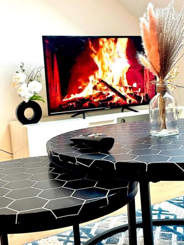 een tafel met een vuur voor een tv bij La perle des capucins in Reims
