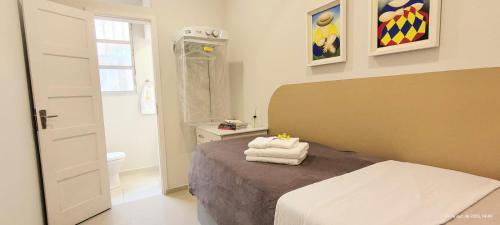 apto 4 quartos 50 metros da praia في باليريو كامبوريو: غرفة نوم بها سرير مع مناشف عليه