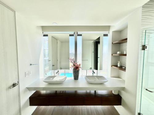 a bathroom with two sinks and a large mirror at Departamento Lobby 33 in Guadalajara