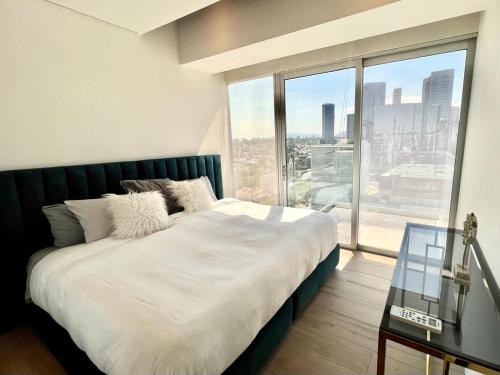 a bedroom with a large bed with a large window at Departamento Lobby 33 in Guadalajara