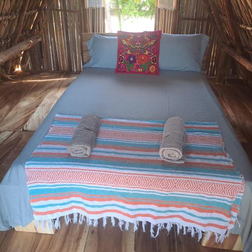 a bed with two pillows and towels on it at Chak in Tonalá