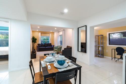 a dining room and living room with a table and chairs at Beautiful, fully furnished 2bed 1bath house - 5 minute walk to Miracle Mile Downtown Coral Gables in Miami