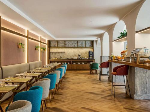 un restaurant avec une rangée de tables et de chaises dans l'établissement Hotel Giacomo Morra Alba - Handwritten Collection, à Alba