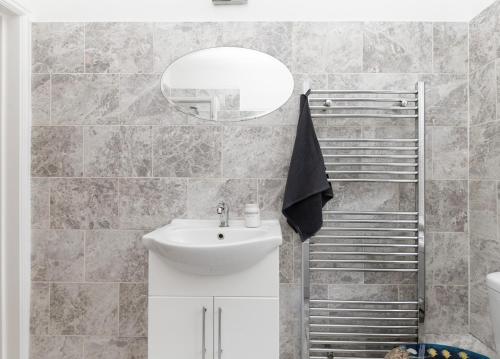ein Badezimmer mit Waschbecken und Spiegel in der Unterkunft 3 Beds house sleeps 5 Free Parking on drive London Romford PET friendly in Romford