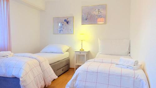 a room with two beds and a lamp in it at Hostel City Basel 308 in Basel
