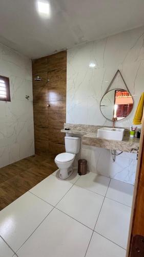 a bathroom with a toilet and a sink and a shower at Encanto de paracuru in Paracuru