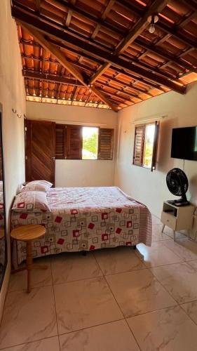 a bedroom with a bed and a table in it at Encanto de paracuru in Paracuru