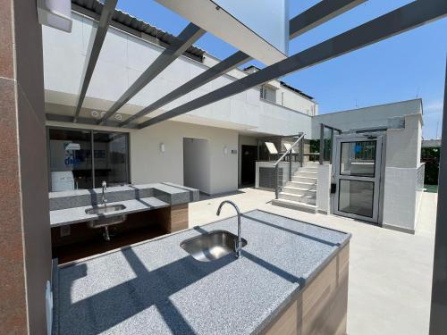 una cocina exterior con fregadero de acero inoxidable en una casa en Apart Hotel Praia Ingá Quarto, Sala, 2 Varandas e Vista Parcial MAC, en Niterói