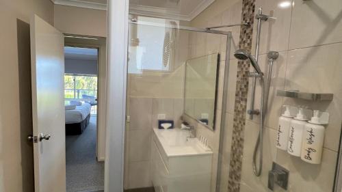 une salle de bain avec une douche et un lavabo et une douche dans l'établissement Fishpen Views, à Merimbula
