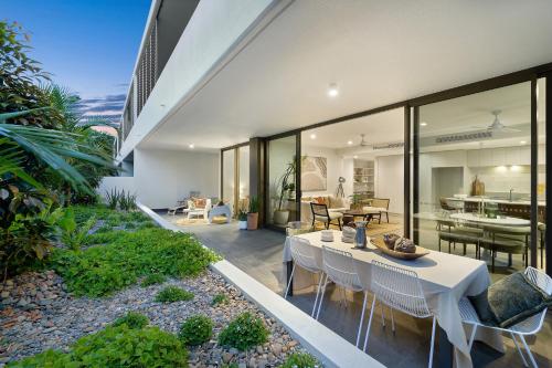 Un comedor con una mesa y sillas en una casa. en Aurelia Byron, en Byron Bay