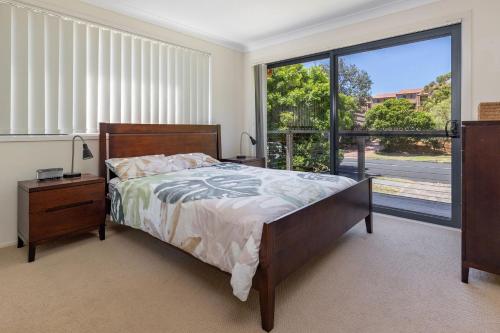 ein Schlafzimmer mit einem Bett und einem großen Fenster in der Unterkunft Barrels at Boomerang in Boomerang Beach