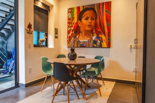 einen Tisch mit Stühlen und ein Bild einer Frau in der Unterkunft Casita Cobojo in Bucerías