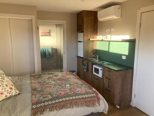 une petite chambre avec un lit et un lavabo dans l'établissement Jimmies on Saltwood, à Tomakin