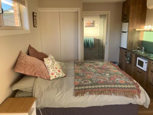 a small bedroom with a bed with pillows on it at Jimmies on Saltwood in Tomakin