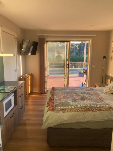 a bedroom with a bed and a sliding glass door at Jimmies on Saltwood in Tomakin