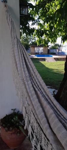 un hamac suspendu sur une terrasse couverte avec une plante dans l'établissement En lo de Ana, à Villa Dolores