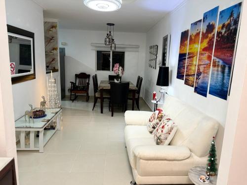 a living room with a white couch and a table at Apartamentos en Pablo mellas morales 3ra etapa M-R42 Apt 101 Santo Domingo in Hato Nuevo