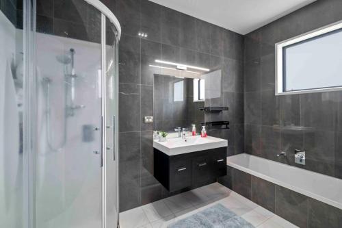 une salle de bain avec une douche, un lavabo et une baignoire dans l'établissement 6 Bedrooms Hillside Lodge, à Rotorua