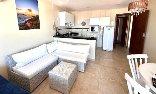 a living room with a couch and a kitchen at Eu Amo Arraial Hospedagem - Sophia I Orla Praia Grande in Arraial do Cabo