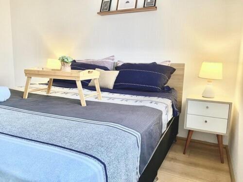 a bedroom with a bed with blue pillows and a table at Nuevo Exclusivo con vista panoramica al mar - Ocean View in Lima