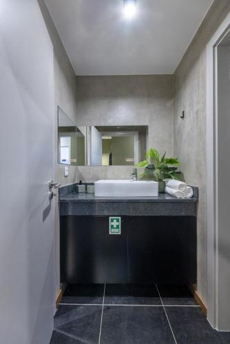 a bathroom with a sink and a large mirror at THE SPOT- holiday concept in Santa Cruz