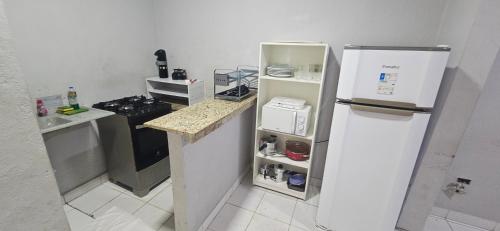 a small kitchen with a refrigerator and a stove at Quarto com otima localização in Manaus