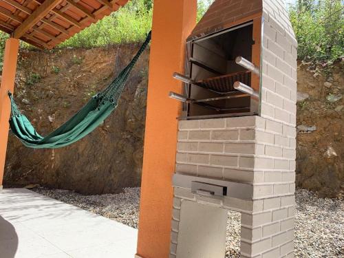 a brick oven with a hammock in the background at CASA da CHi in Piranhas