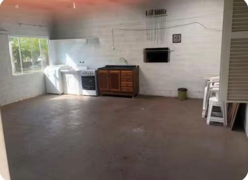 a kitchen with a stove and a sink in a room at Casa de praia - 2 quadras do mar in Arroio do Sal