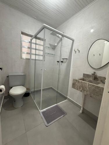 un bagno con doccia, WC e lavandino di Casa Bertioga Centro a Bertioga