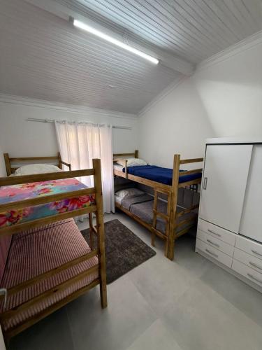Camera con 2 letti a castello e un frigorifero. di Casa Bertioga Centro a Bertioga