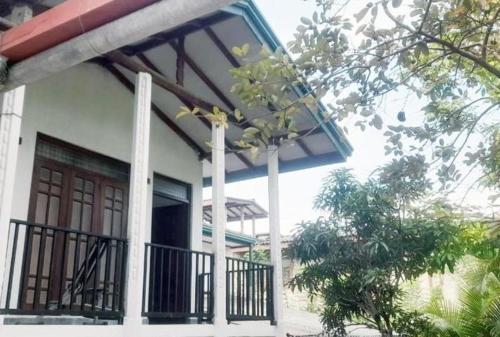 una casa con veranda e balcone di Misty Morning Villa Ella a Medaperuwa