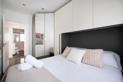 a bedroom with a large white bed with white pillows at PLAYA a 3 minutos Parking barbacoa Apartamento en Castelldefels in Castelldefels