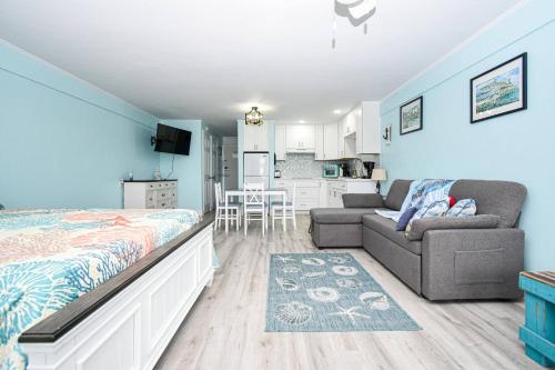 a bedroom with a bed and a couch and a kitchen at Cedar Key Island Condo 228 in Cedar Key