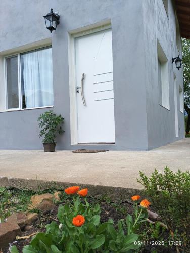 a white door with orange flowers in front of a house at Rincón Bonito in El Hoyo