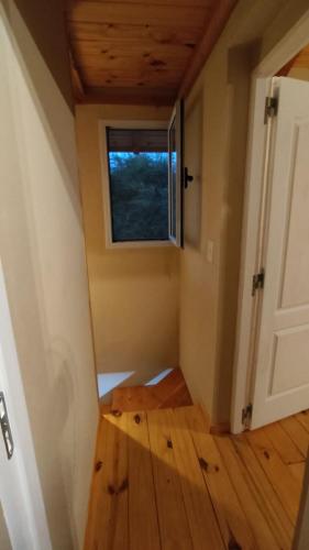 a small room with a window and a wooden floor at Rincón Bonito in El Hoyo