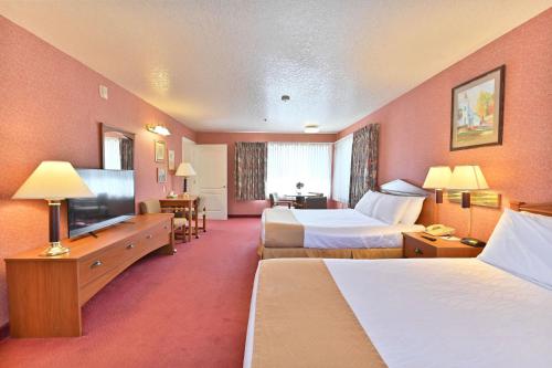 a hotel room with two beds and a flat screen tv at Murphys Suites in Murphys