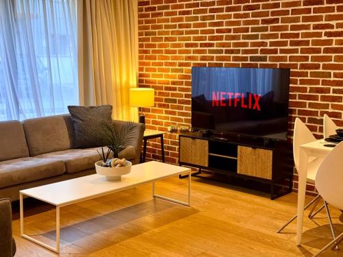 a living room with a couch and a tv at Modern & Luxurious 2-bed by ABBA, O2 & Canary Wharf in London