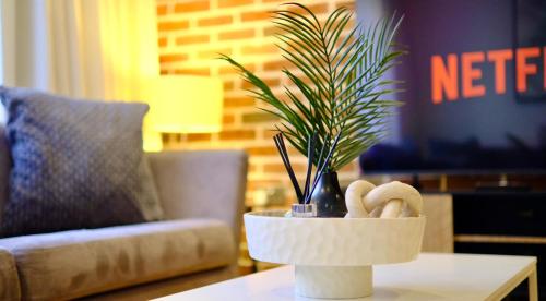 a potted plant on a table in a living room at Modern & Luxurious 2-bed by ABBA, O2 & Canary Wharf in London