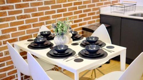 a white table with chairs and a vase of flowers at Modern & Luxurious 2-bed by ABBA, O2 & Canary Wharf in London