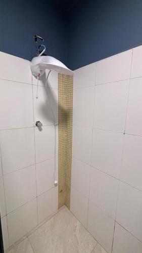 a shower with a shower head in a bathroom at Palais House in São Vicente