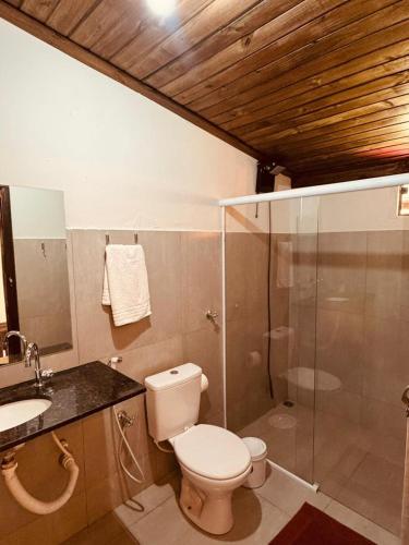 a bathroom with a toilet and a glass shower at Fazenda Brotas SP in Brotas