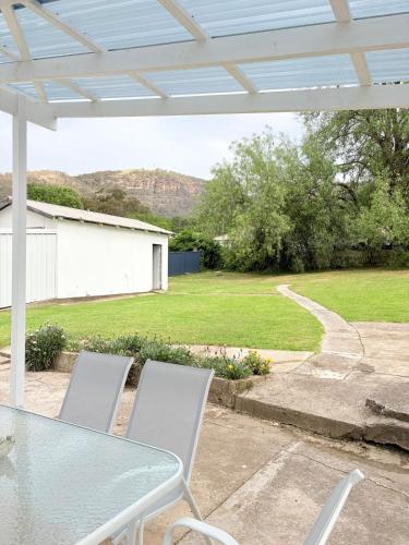 a patio with a table and chairs and a yard at The Kandos Nook- Adventure, Wine & Country Charm in Kandos