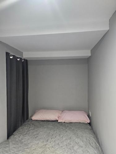 a bedroom with a bed with pink pillows at Penge lovely studio in Sydenham