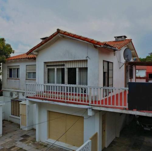 ein weißes Haus mit Balkon und Zug in der Unterkunft Casa en Alquiler San Bernardo in San Bernardo